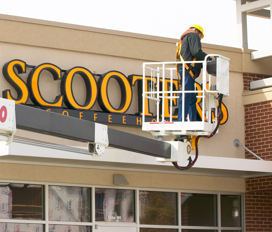 Technician servicing an illuminated Scooter's Coffee channel letter sign in Chicago, IL