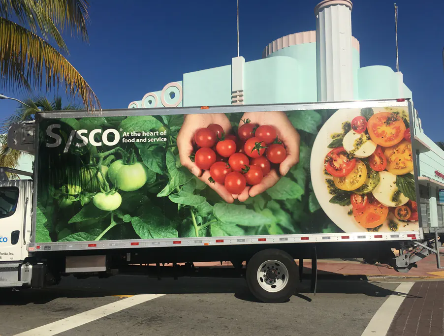 Full-color printed wrap covering the side of a box truck